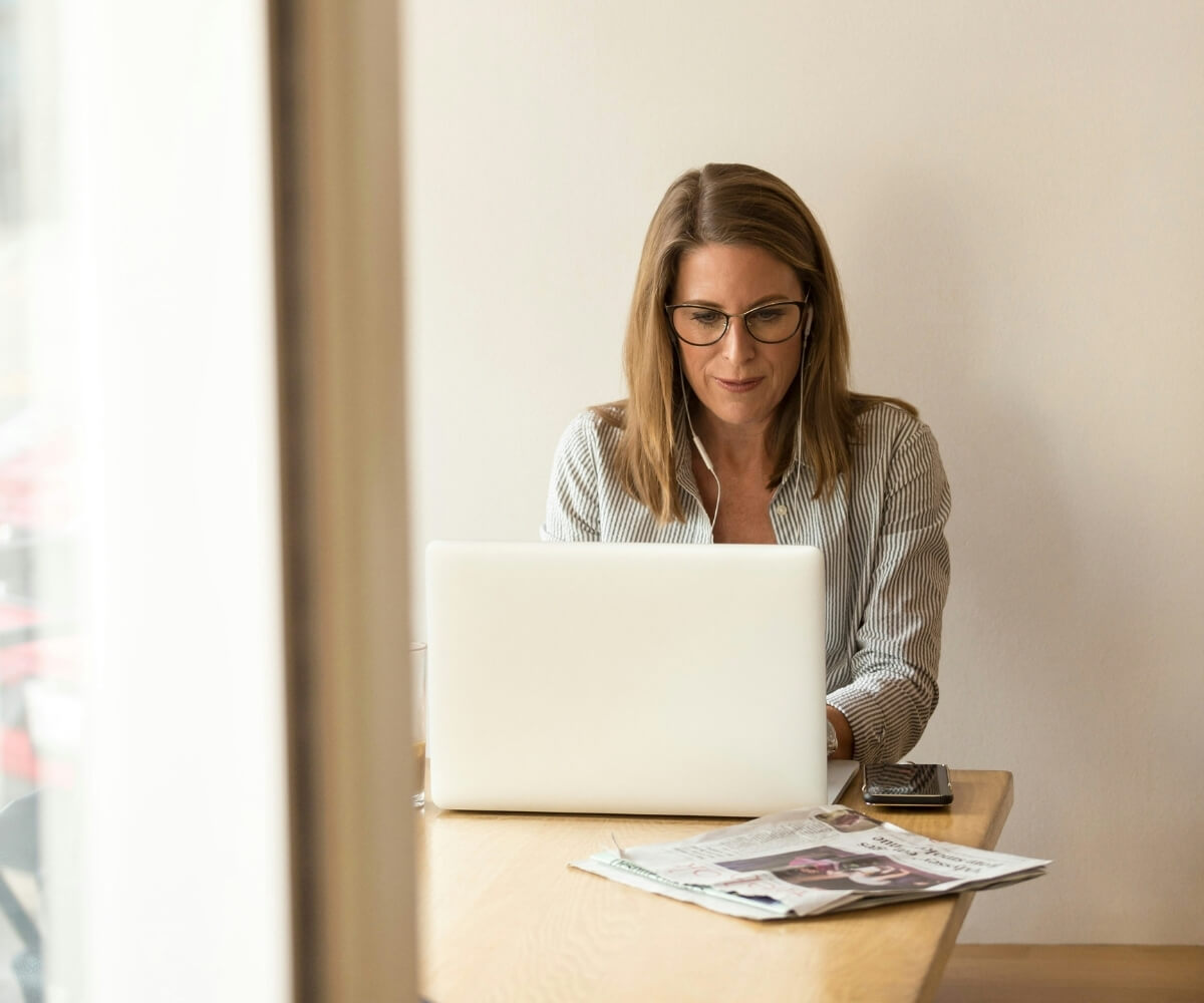 Femme avec lunettes travaillant sur ordinateur portable